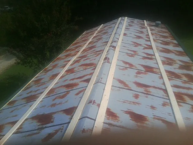 Rusted metal roof panels with new wood purlins before replacement — Storm Damage Roof Repair in Coos Bay by Roofing Brothers