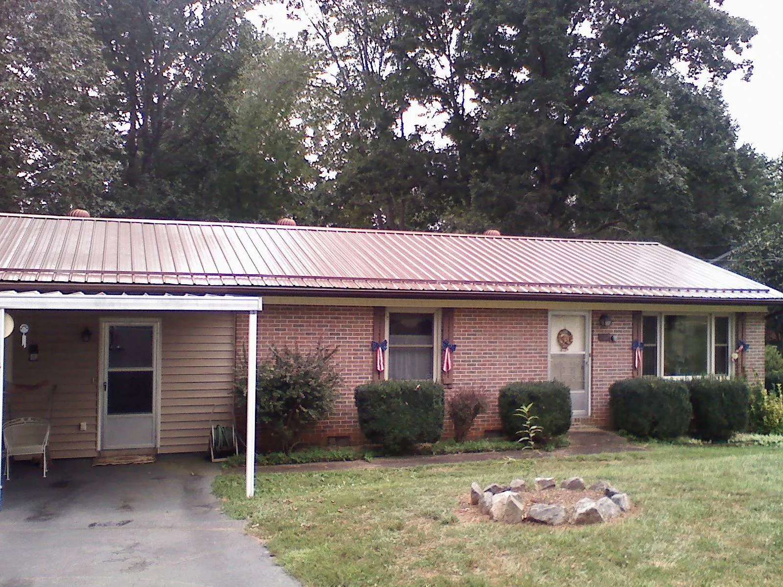 Bronze metal roof and carport on a brick ranch home — Roof Repair work by our crew in Coos Bay